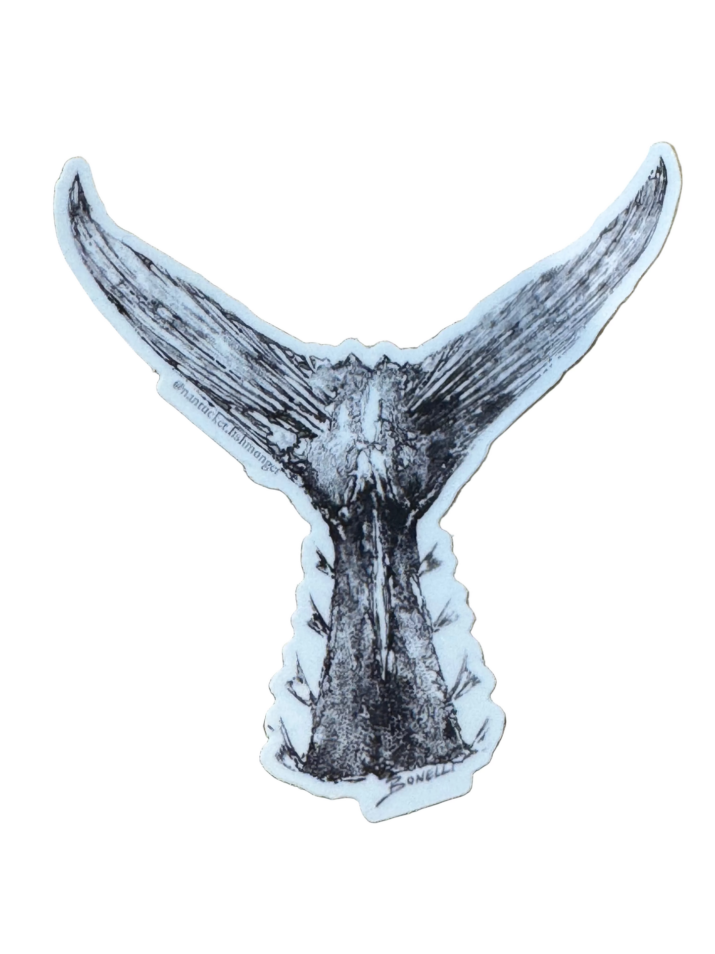 Sticker of a whale tail on a wooden surface